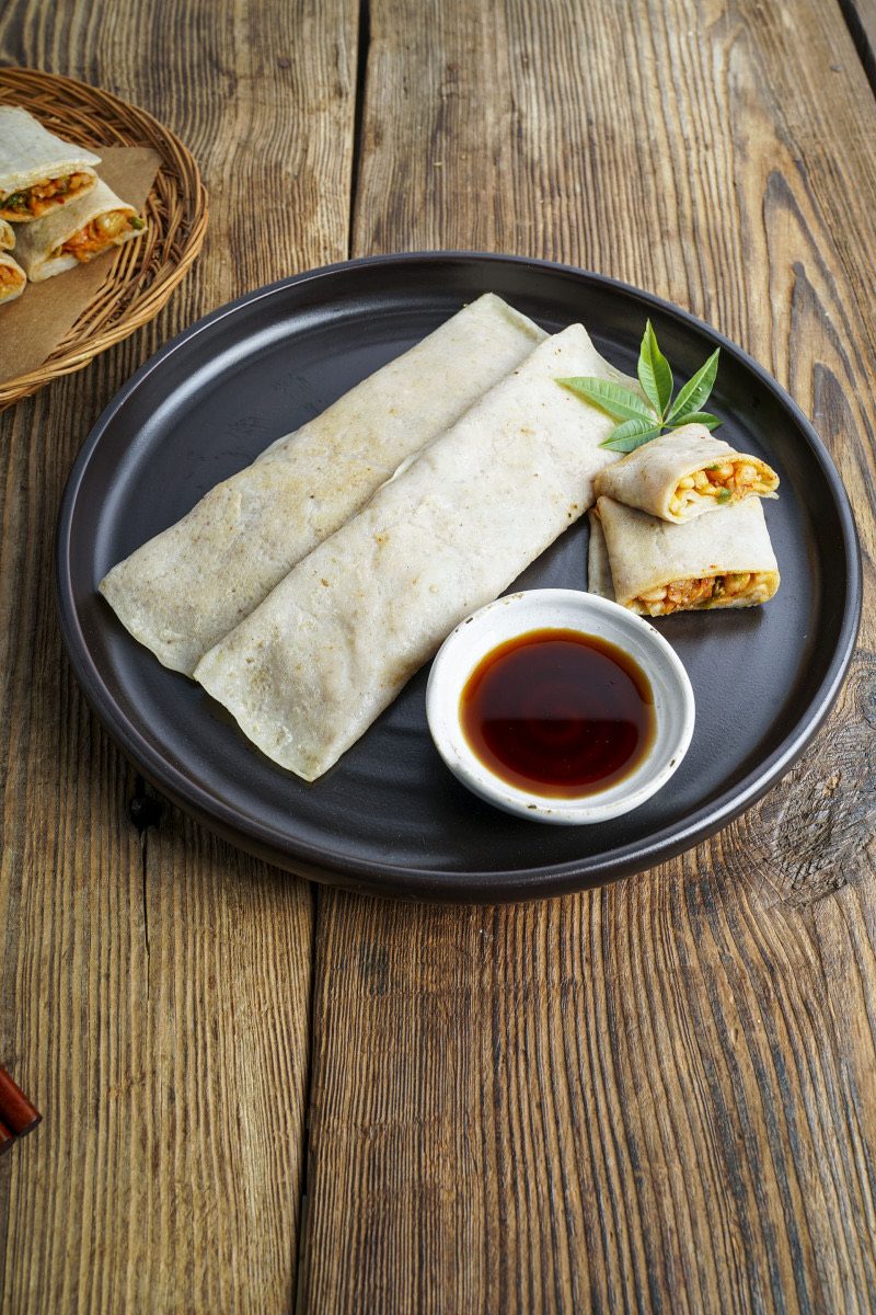 검은 접시에 간장과 함께 담아낸 메밀전병